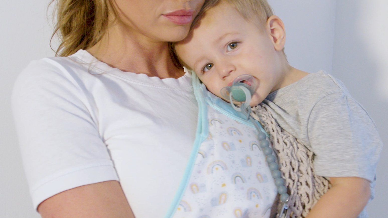 Mother comfortably holding baby with Cool Cuddle cooling vest